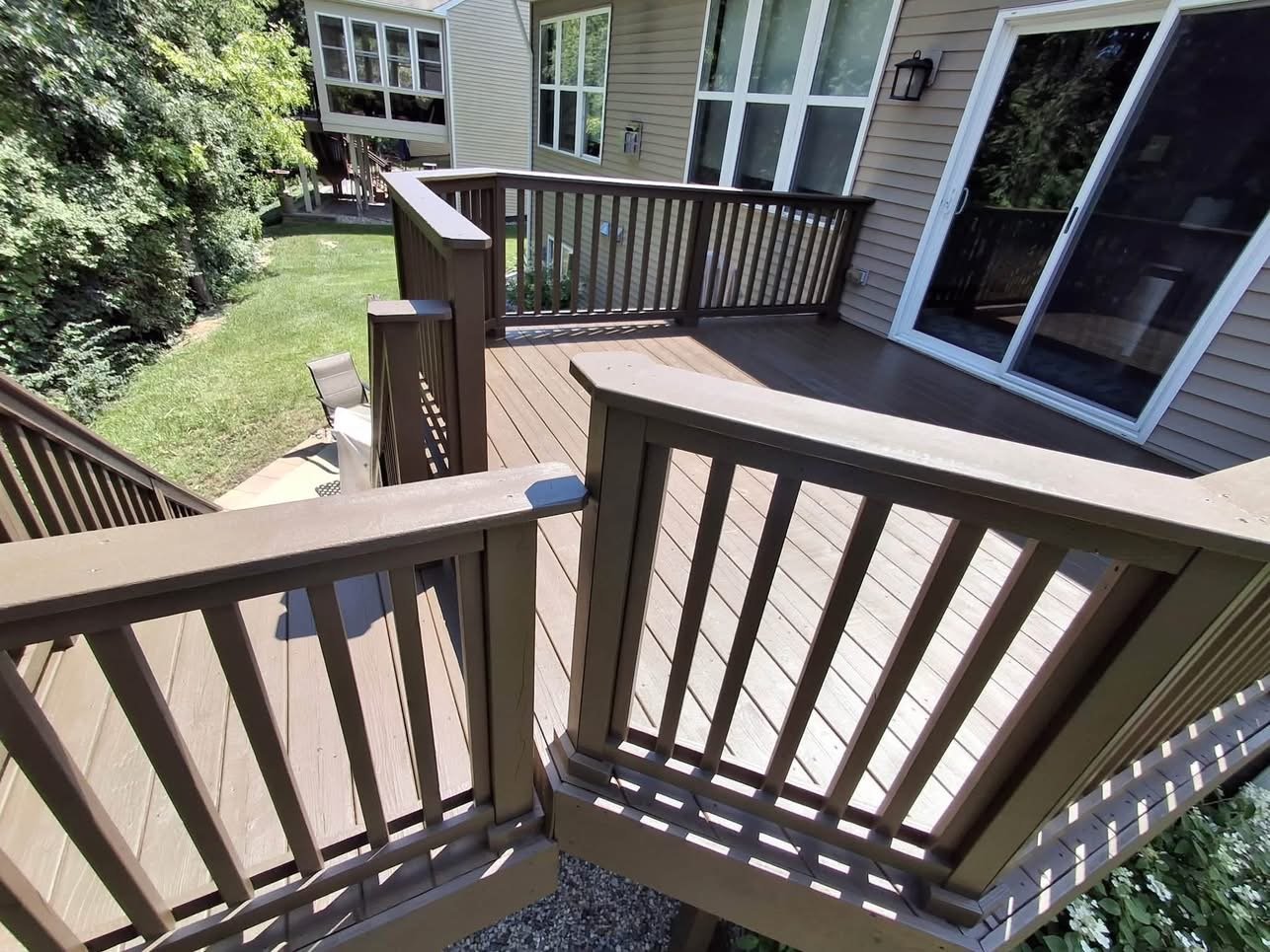 Multi-level wooden deck with black railings by Central Ohio Deck Staining