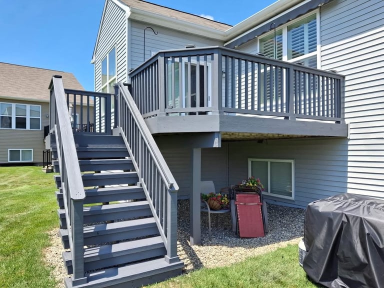 Two-story gray house with black exterior deck and stairs by Central Ohio Deck Staining