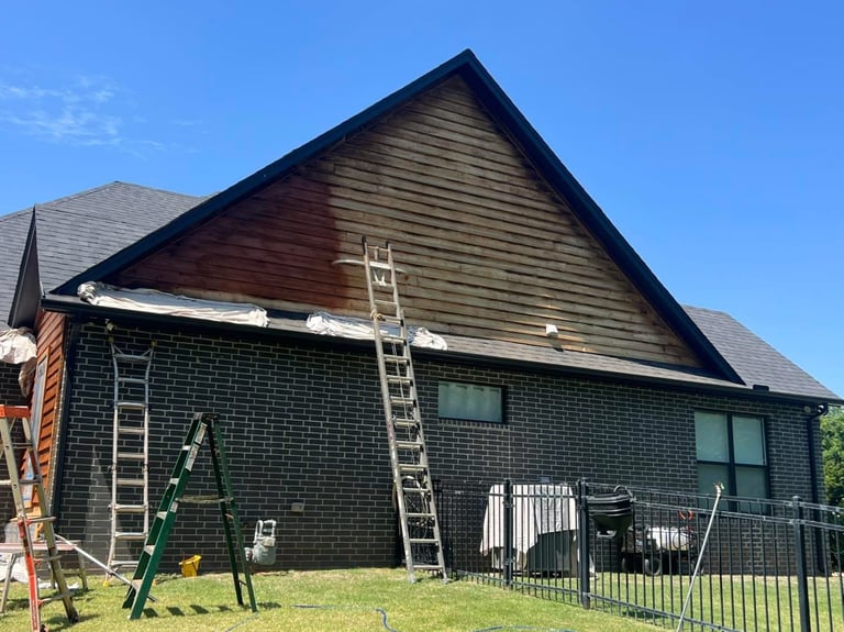 Brick house with dark wooden gable roof under renovation by Central Ohio Deck Staining